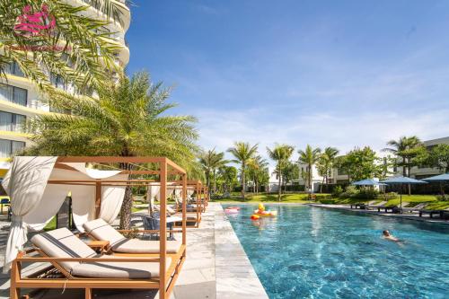 a pool at a resort with chairs and people in it at Lux Resort Apartment/2BR/Private Beach/Pools in Hà My Tây (2)