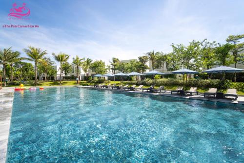 a large swimming pool with chairs and umbrellas at Lux Resort Apartment/2BR/Private Beach/Pools in Hà My Tây (2)