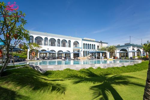 a large building with a swimming pool in front of it at Lux Resort Apartment/2BR/Private Beach/Pools in Hà My Tây (2)
