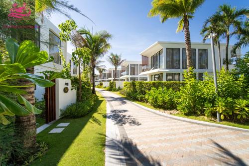 a walkway in front of a house with palm trees at Lux Resort Apartment/2BR/Private Beach/Pools in Hà My Tây (2)
