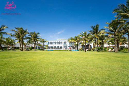 a park with palm trees in front of a building at Lux Resort Apartment/2BR/Private Beach/Pools in Hà My Tây (2)