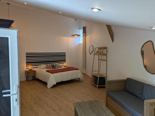 ein Schlafzimmer mit einem Bett und einer Couch in der Unterkunft Maison rénovée avec jardin et espace détente proche Bergerac - FR-1-616-425 in Razac-de-Saussignac