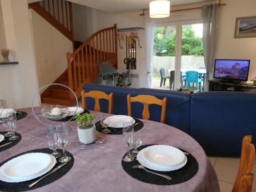 une table de salle à manger avec des assiettes et des verres dessus dans l'établissement Maison 3 chambres près plage, animaux acceptés, parking, Sarzeau - FR-1-775-10, à Sarzeau