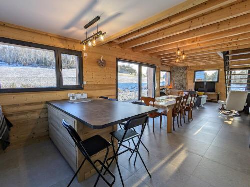 une cuisine et une salle à manger avec une table et des chaises dans l'établissement Chalet Nature avec Sauna et WIFI près Gérardmer - FR-1-589-777, à Anould