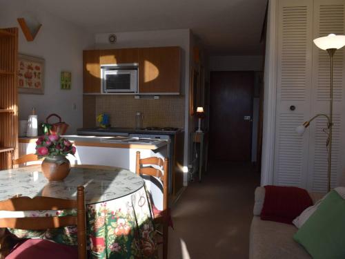 une cuisine avec une table avec un vase dessus dans l'établissement Studio Mezzanine 6 Pers, Proche Skibus, Parking - FR-1-580-129, à Font-Romeu-Odeillo-Via