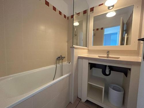 une salle de bain avec un lavabo, une baignoire et un miroir dans l'établissement T3 rénové avec piscine et parking au Cap d'Agde - FR-1-749-79, au Cap d'Agde