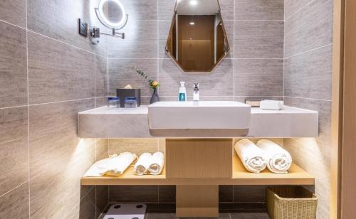 a bathroom with a sink and a mirror at Atour Hotel Wuhan Donghu Yuejiazui in Wuhan