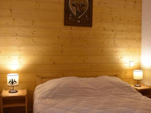 - une chambre avec des murs en bois et un lit avec deux lampes dans l'établissement Appartement 2 pièces à Méribel avec parking proche ski - FR-1-180-646, à Les Allues