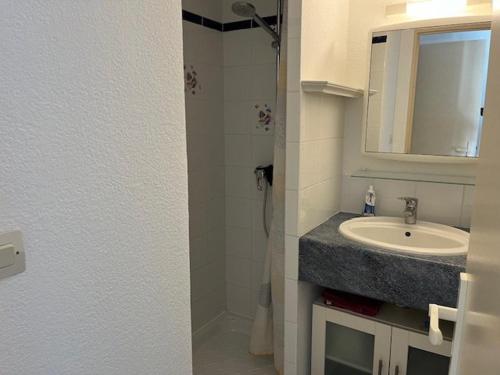 une salle de bain avec un lavabo et un miroir dans l'établissement Appartement T3 avec piscine et golf, Cap d'Agde - FR-1-749-78, au Cap d'Agde