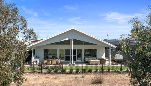 a white house with a fence in front of it at Paradise on the Fairway in Yarrawonga