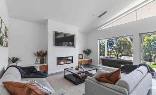 a living room with two couches and a fireplace at Paradise on the Fairway in Yarrawonga