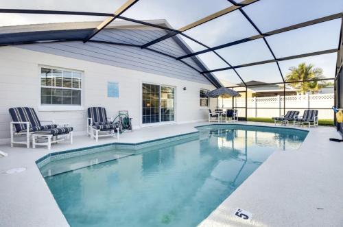 an indoor swimming pool with a glass roof and chairs at Florida Gem in Kissimmee