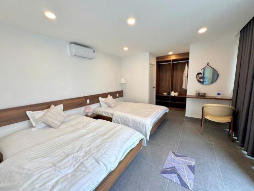 a hotel room with two beds and a table at Malis Homestay in Trà Vinh