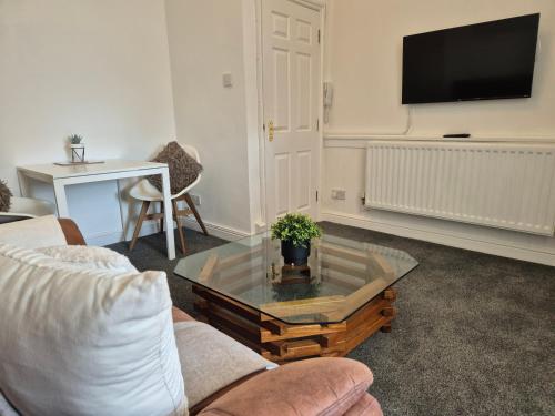 a living room with a coffee table and a tv at #26b Renovated Portsmouth Flat in Portsmouth