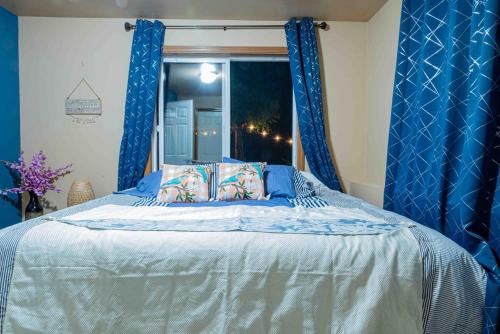 ボセルにある2 King Bed, Kitchenette, Game Area, Living Room, Office Room, Backyardのベッドルーム(青いカーテン付きのベッド1台付)