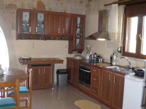 a kitchen with wooden cabinets and a sink at Vasiliki's Residence Amazing View in Kissamos