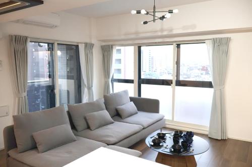 a living room with a couch and a table at Creare Togoshi Ginza by Tranova in Tokyo