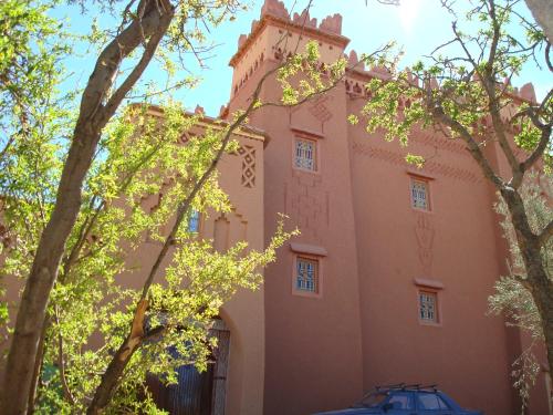 a building with trees in front of it at Kasbah Ait Kassi in Boumalne
