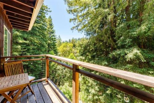 a deck with a bench and a view of the woods at Evergreen Escape in Felton