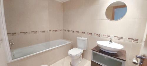 łazienka z umywalką, toaletą i wanną w obiekcie Cosy Apartment in Castellón with Shared Pool, 55 sqm w mieście San Rafael del Río