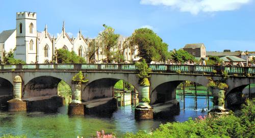 a bridge over a river in front of a building at Cosy Apartment in Galway with Balcony, 32 m², City View in Galway