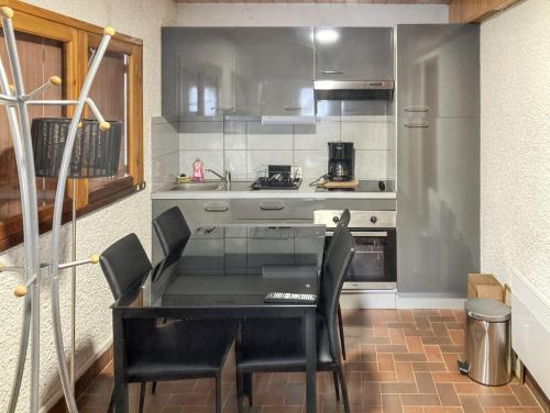 une cuisine avec une table noire et des chaises noires dans l'établissement Chalet authentique à Saint-Lary-Soulan avec vue sur la montagne, à Saint-Lary-Soulan