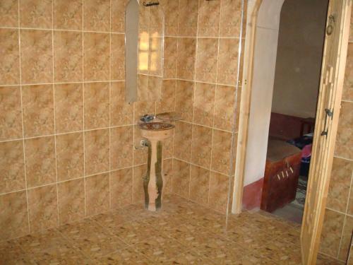 a bathroom with a sink in a tiled shower at Kasbah Ait Kassi in Boumalne
