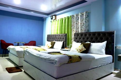 a bedroom with a large bed with blue walls at Darjeeling Homes The Grace in Darjeeling