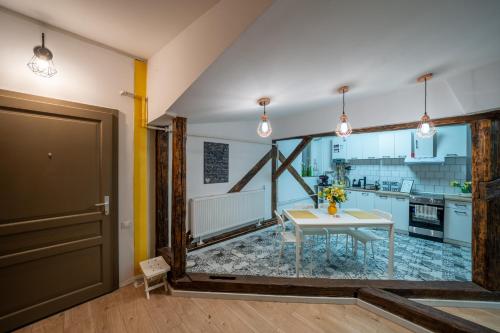 a living room with a table and a kitchen at Loft in 1902 Art-Nouveau Villa in Oradea