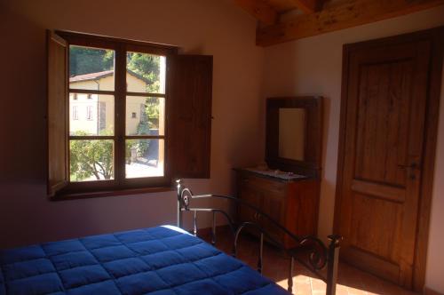 a bedroom with a bed and a window and a mirror at agriturismo il poderetto in Licciana Nardi