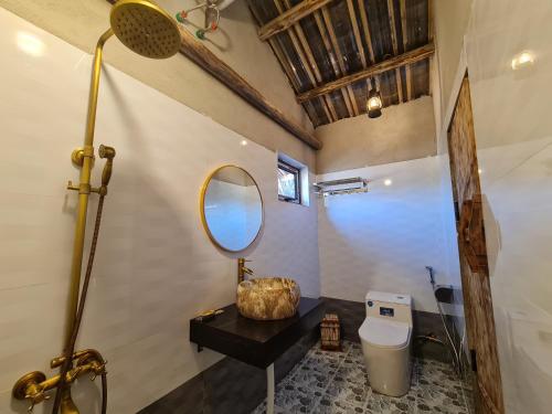 un baño con inodoro y espejo en Nhà Cổ Lao Xa Homestay Hmong & Bungalow air conditioner, en Dồng Văn