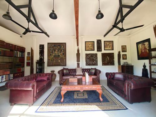 a living room with leather couches and a coffee table at Mintys Folly 2 in Ban Man
