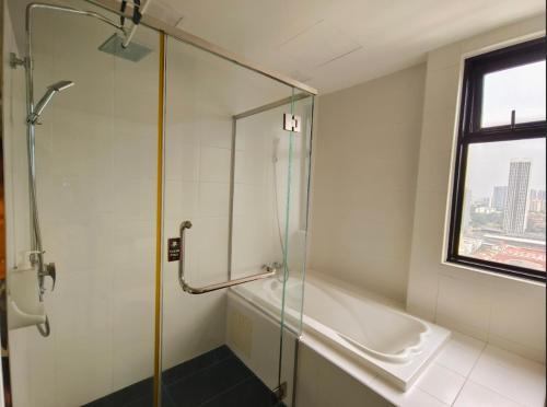 a bathroom with a glass shower and a tub at Encorp Strand Suite by Luvit Stay in Petaling Jaya