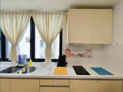 a kitchen with a sink and two windows at Encorp Strand Suite by Luvit Stay in Petaling Jaya
