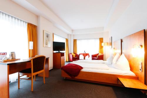 a hotel room with a bed and a desk at Hotel am Tiergarten in Karlsruhe