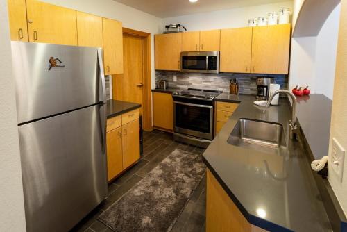 Solitudeにある4315A - One Bedroom Deluxe Creekside Condominiums condoのキッチン(ステンレス製の冷蔵庫、木製キャビネット付)