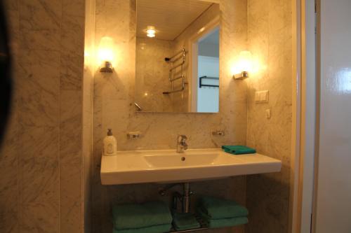 a bathroom with a sink and a mirror at Berrie's Sea View in Zandvoort