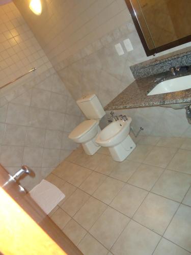 a bathroom with a toilet and a sink at Hotel Green Village in Jardinópolis