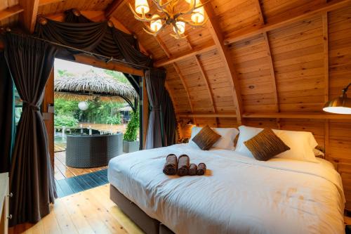 a bedroom with a bed with two pairs of shoes on it at Khum Damnoen Resort in Ratchaburi