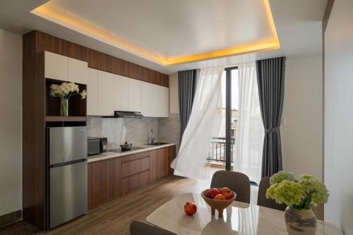 a kitchen with a table with a bowl of fruit on it at Anteaus Hotel Đà Lạt in Da Thien