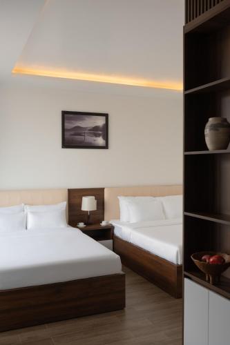 a bedroom with two beds and a book shelf at Anteaus Hotel Đà Lạt in Da Thien