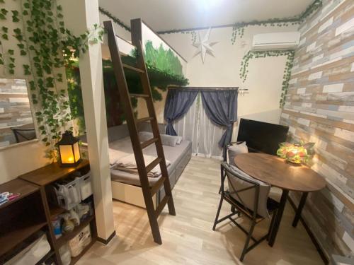 a small room with a bunk bed and a table at Private & Cozy Studio Okegawa in Okegawa
