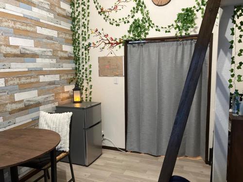 a kitchen with a table and a refrigerator and a window at Private & Cozy Studio Okegawa in Okegawa