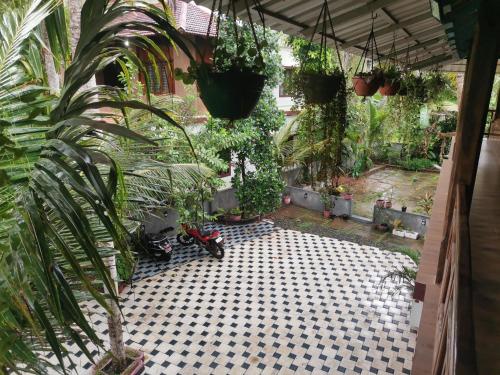 a courtyard with a lot of plants and a scooter at Kailasahomestay & Ayurvedic Spa in Pūvār