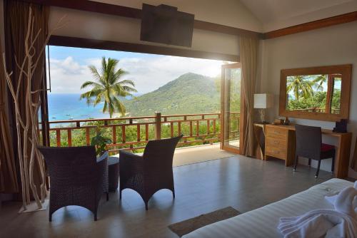 a bedroom with a balcony with a view of the ocean at Perfect View Pool Villa in Koh Tao