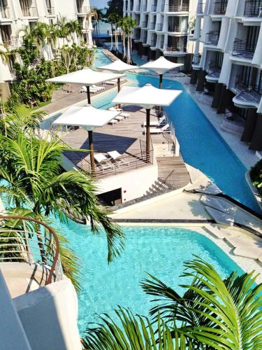 an overhead view of a swimming pool with umbrellas at บ้านแสนคราม ห้องติดสระ Baan San Kraam HUA HIN Family Room - Pool Access in Phetchaburi