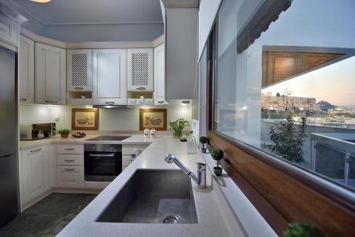 uma cozinha com um lavatório e uma grande janela em KARYATIS LUXURY MAISONETTE by K&K em Atenas
