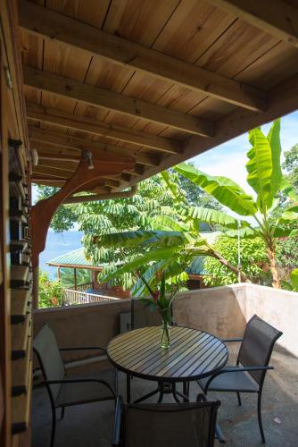 a table and chairs on a patio with a tree at Castara Retreats in Castara
