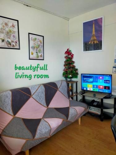 a living room with a couch and a christmas tree at Two-Bedroom at San Remo Oasis in Cebu City