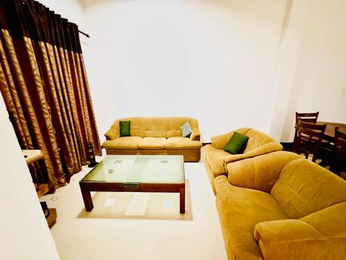 a living room with two couches and a coffee table at Himo Guest Inn in Dehiwala